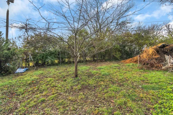 a front view of a house with a yard street and trees