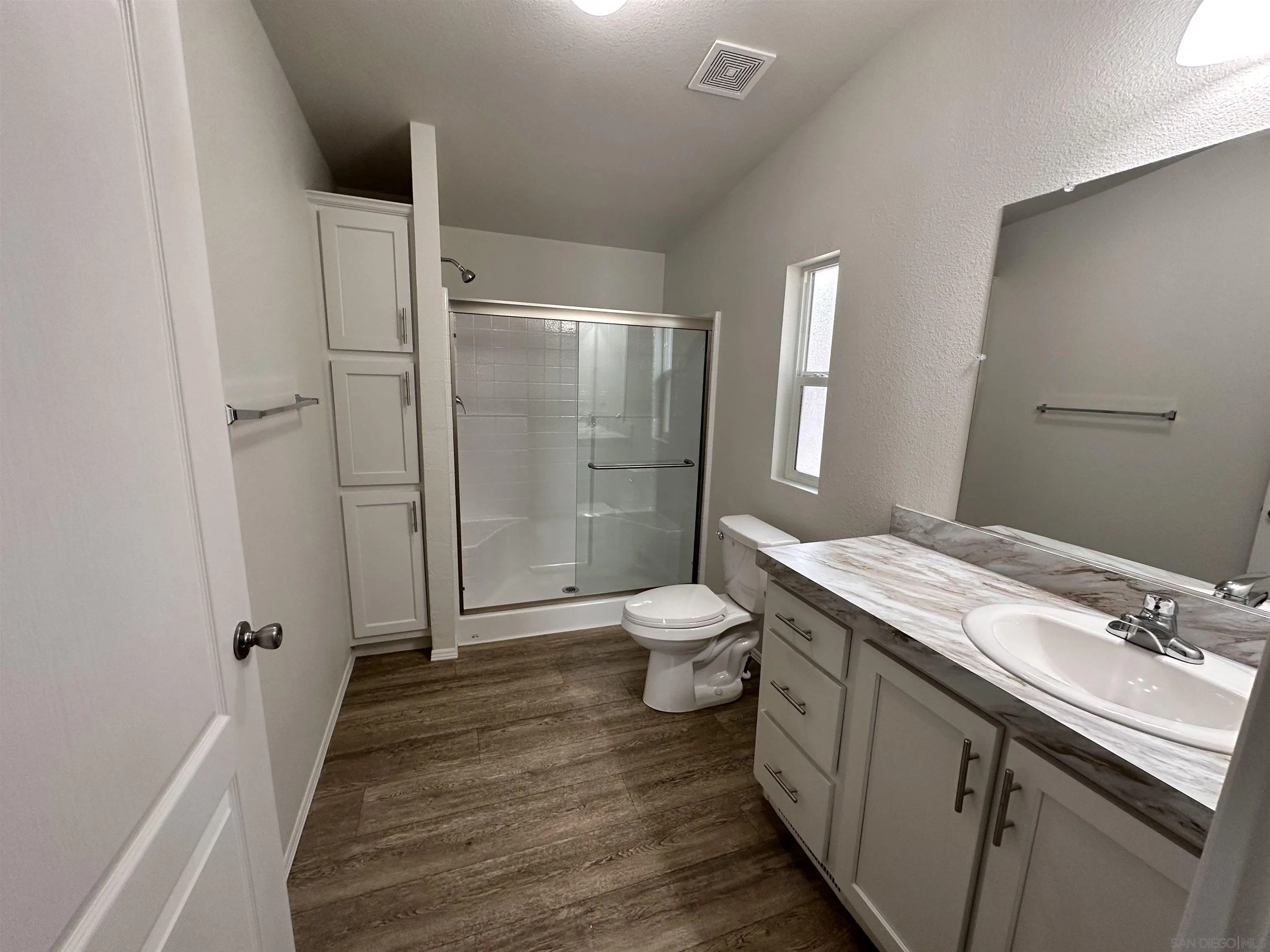 22899 Byron Road, Unit 29 Crestline, CA 92325 - Photo 6 of 8 a bathroom with a granite countertop toilet a sink and a shower