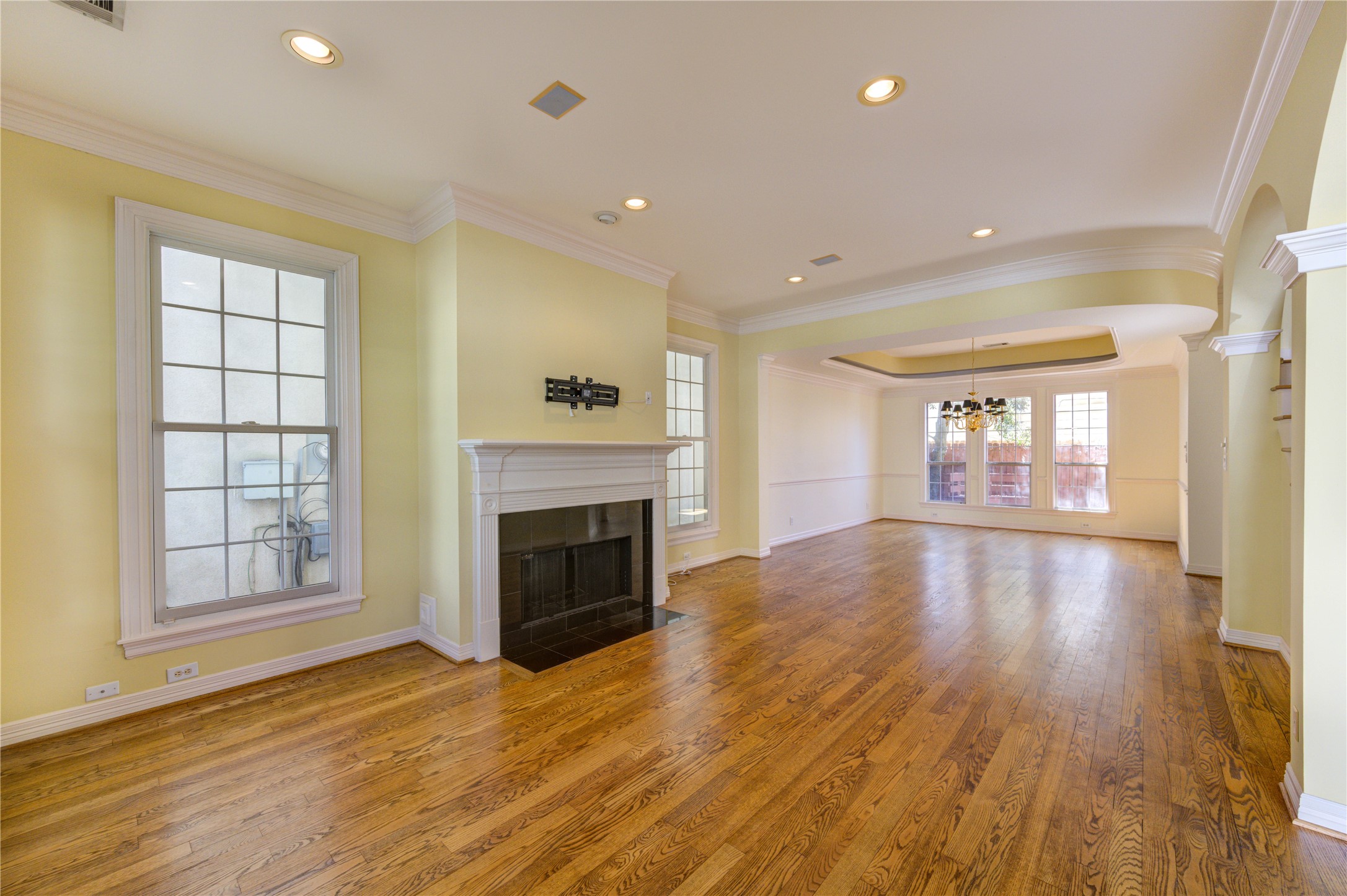 2124 Nantucket Drive, Unit B Houston, TX 77057 - Photo 4 of 35 Spacious living area featuring rich hardwood flooring, crown molding, recessed lighting, and a classic fireplace with elegant mantel.
