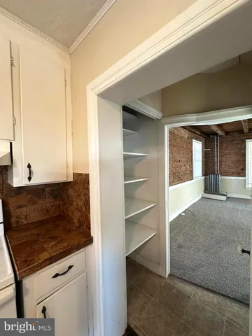 a living room with stainless steel appliances kitchen island granite countertop a refrigerator and a sink