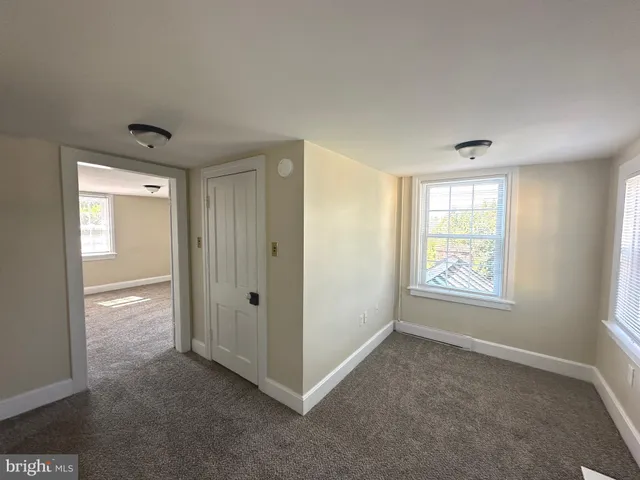 a view of an empty room with window and closet area
