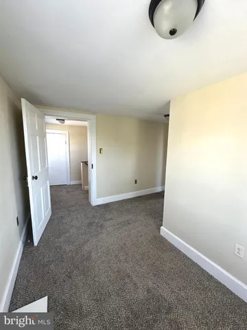 an empty room with a window and a painting on the wall