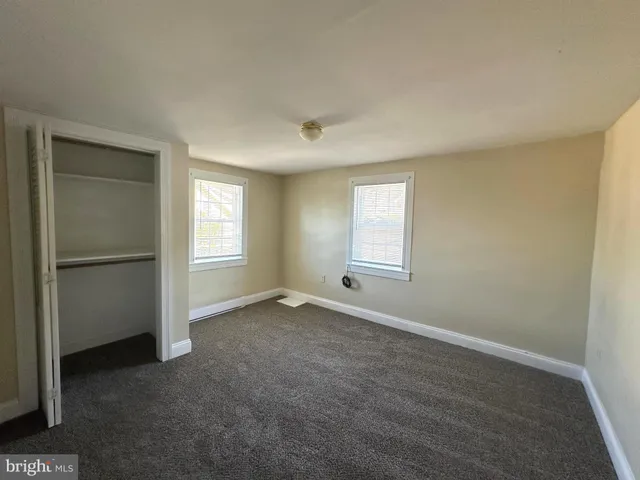 an empty room with windows and closet