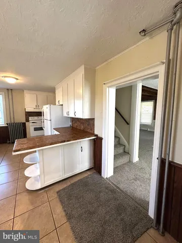 a large kitchen with kitchen island granite countertop a refrigerator and a sink