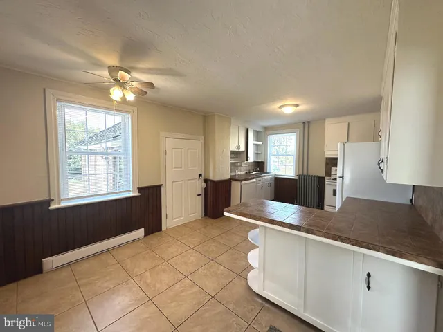 a large kitchen with kitchen island granite countertop a sink window and refrigerator