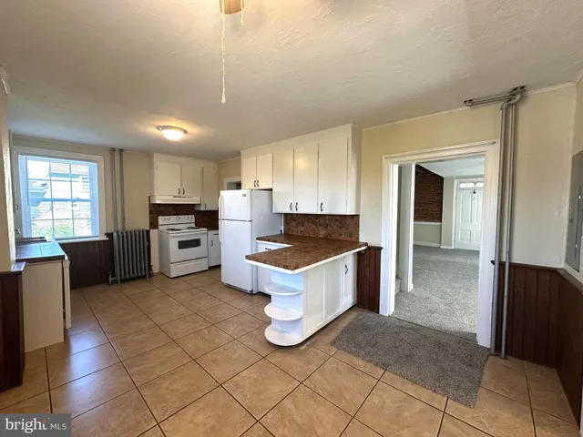 a kitchen with stainless steel appliances kitchen island granite countertop a refrigerator and a stove top oven