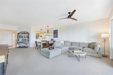 a living room with furniture and a ceiling fan