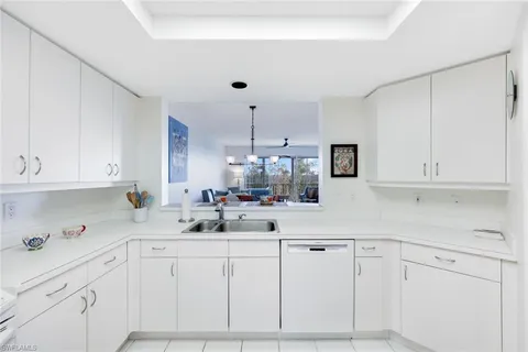 a kitchen with white cabinets and white appliances