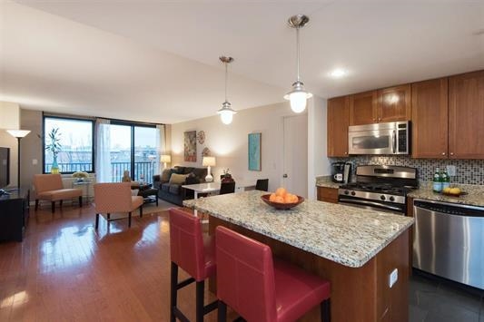 700 Grove Street, Unit 8R Jersey City, NJ 07310 - Photo 1 of 11 a kitchen with sink stove and living room