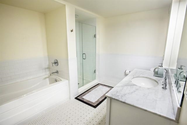 700 Grove Street, Unit 8R Jersey City, NJ 07310 - Photo 6 of 11 a bathroom with a granite countertop sink and a mirror