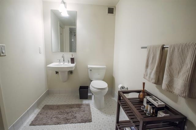 700 Grove Street, Unit 8R Jersey City, NJ 07310 - Photo 7 of 11 a bathroom with a toilet a sink and a mirror