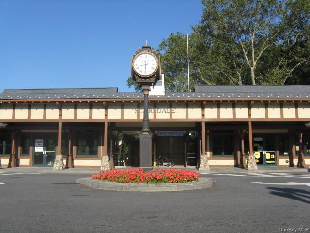 143 Garth Road, Unit 5J Scarsdale, NY 10583 - Photo 41 of 47 front view of a brick building with a large window and a clock