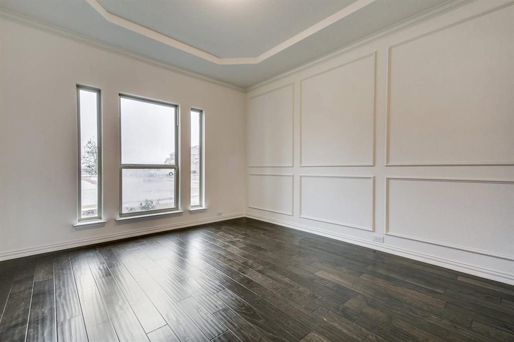 104 Sweetleaf Drive Red Oak, TX 75154 - Photo 8 of 36 Spacious interior featuring dark hardwood flooring, arched doorways, a grand staircase with wrought iron balusters, and large windows providing natural light