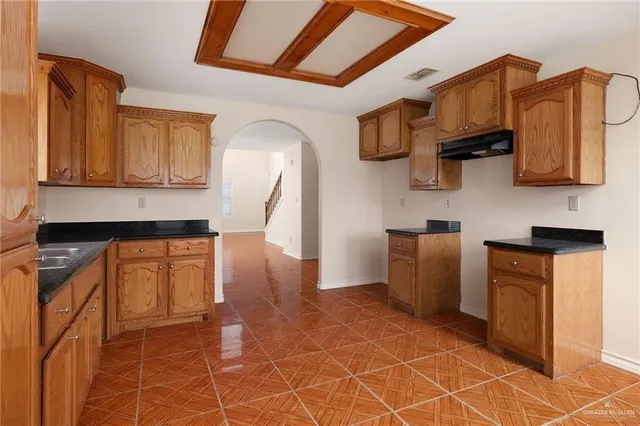 a kitchen with stainless steel appliances granite countertop a stove a sink and a microwave