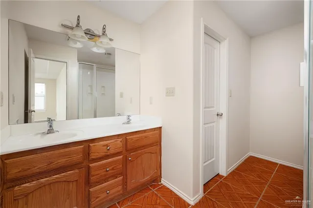 a en suite bathroom with a double vanity sink and a mirror