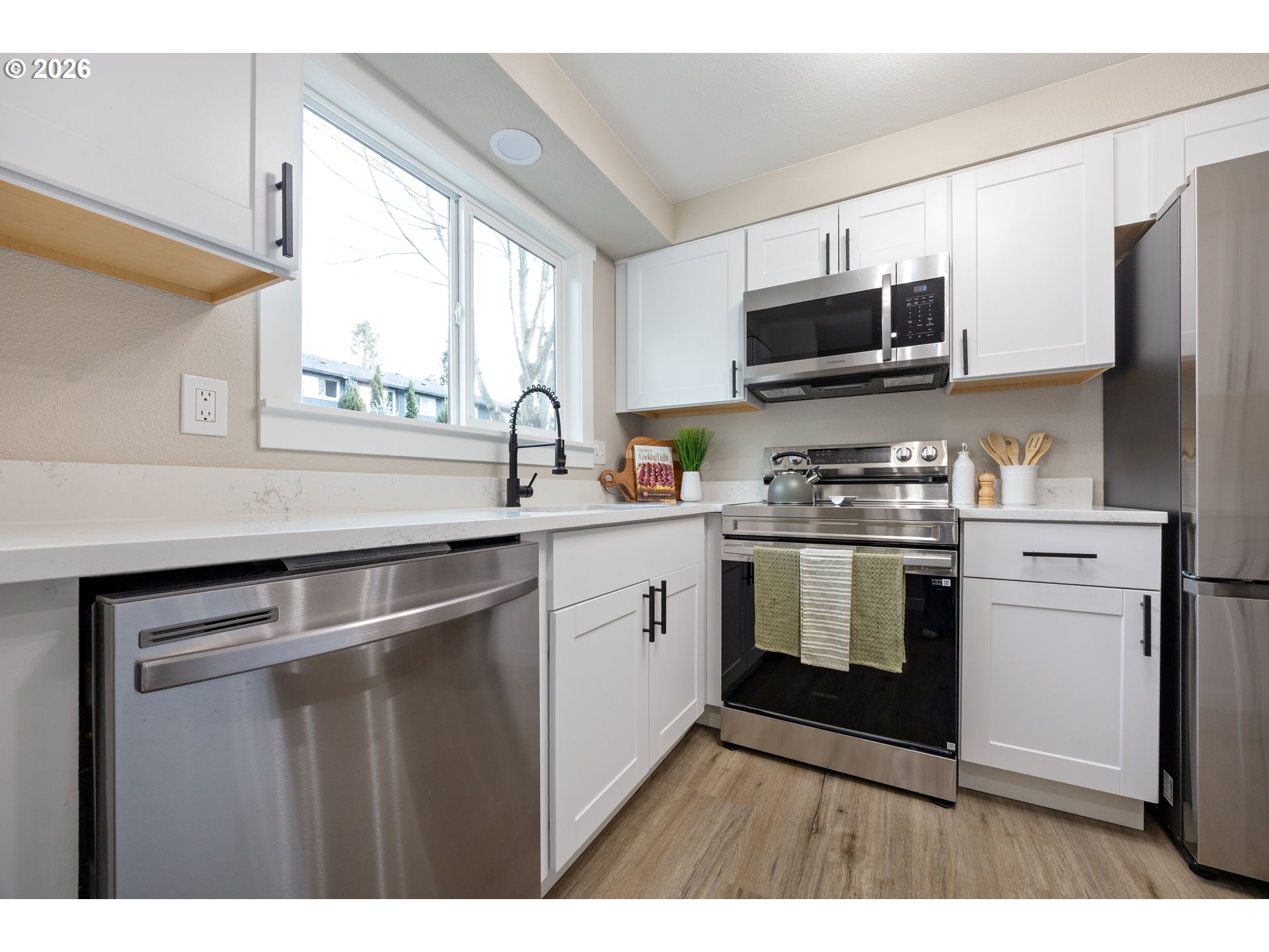 4921 Southwest 59th Avenue, Unit 6 Portland, OR 97221 - Photo 8 of 23 a kitchen with stainless steel appliances a sink cabinets and a window