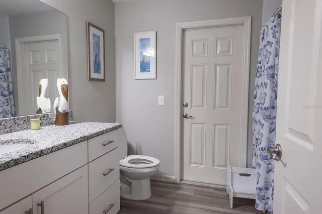 a bathroom with a granite countertop sink toilet and shower