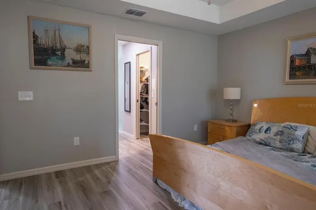 a bedroom with a bed and painting on the wall