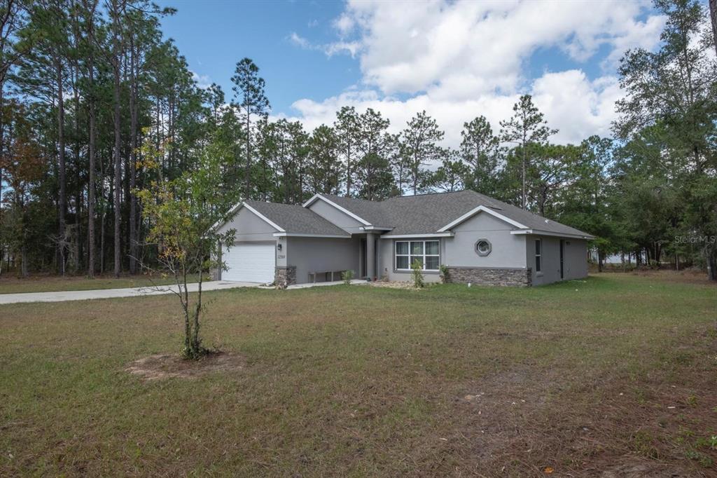 12569 Southwest 73rd Street Ocala, FL 34481 - Photo 2 of 28 a front view of a house with a yard and garage