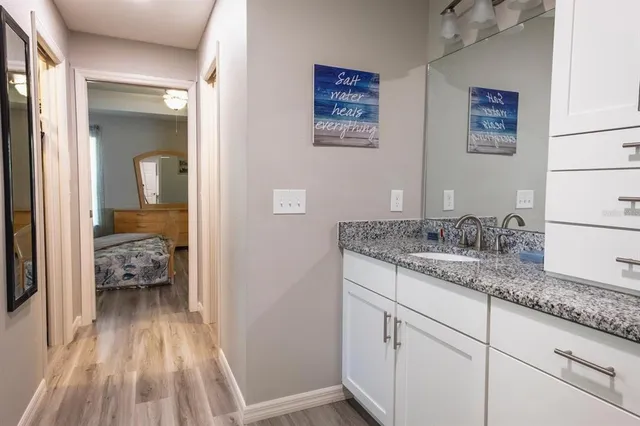 a en suite bathroom with a granite countertop sink and a mirror