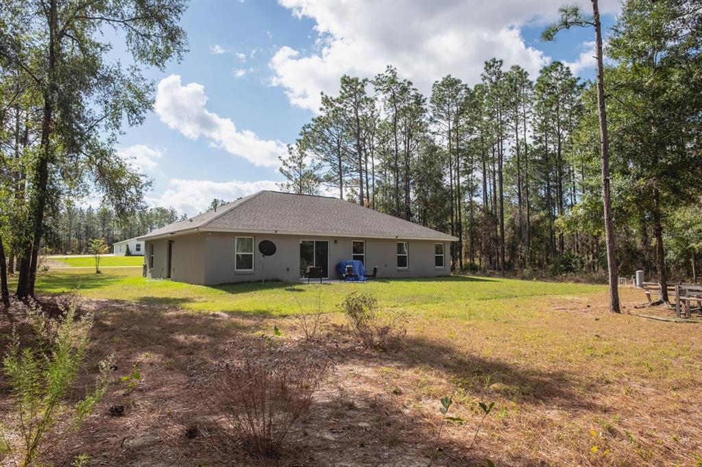 12569 Southwest 73rd Street Ocala, FL 34481 - Photo 27 of 28 a big house with a big yard and large trees