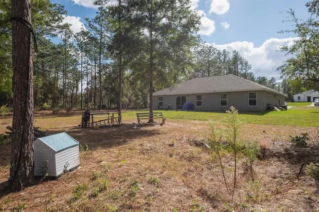 a view of a house with backyard and sitting area