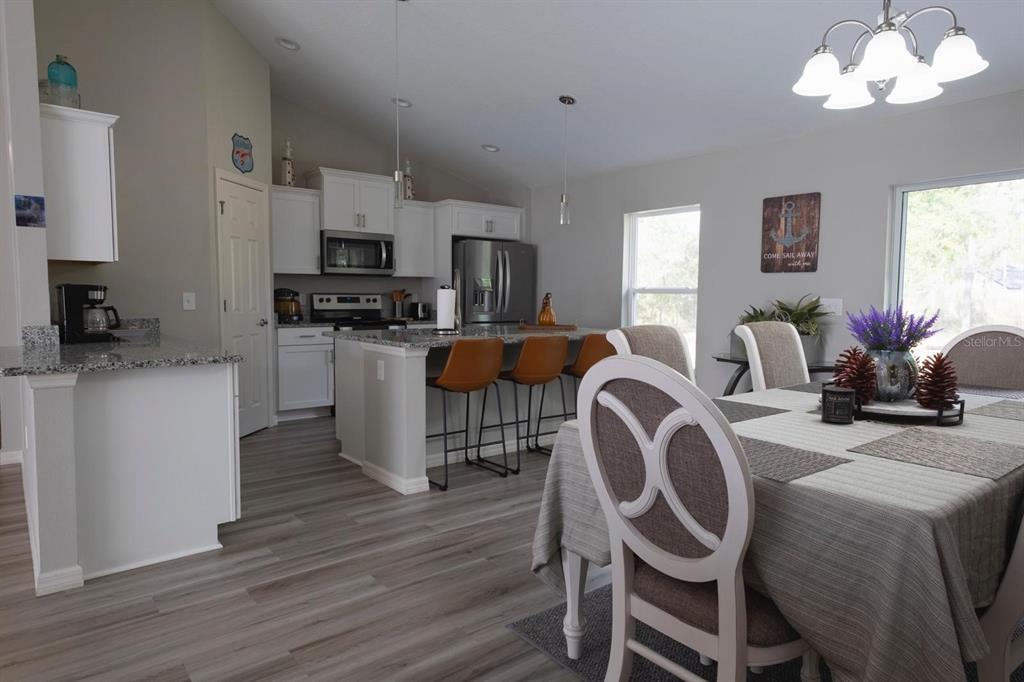12569 Southwest 73rd Street Ocala, FL 34481 - Photo 9 of 28 a dining room with furniture a chandelier and wooden floor