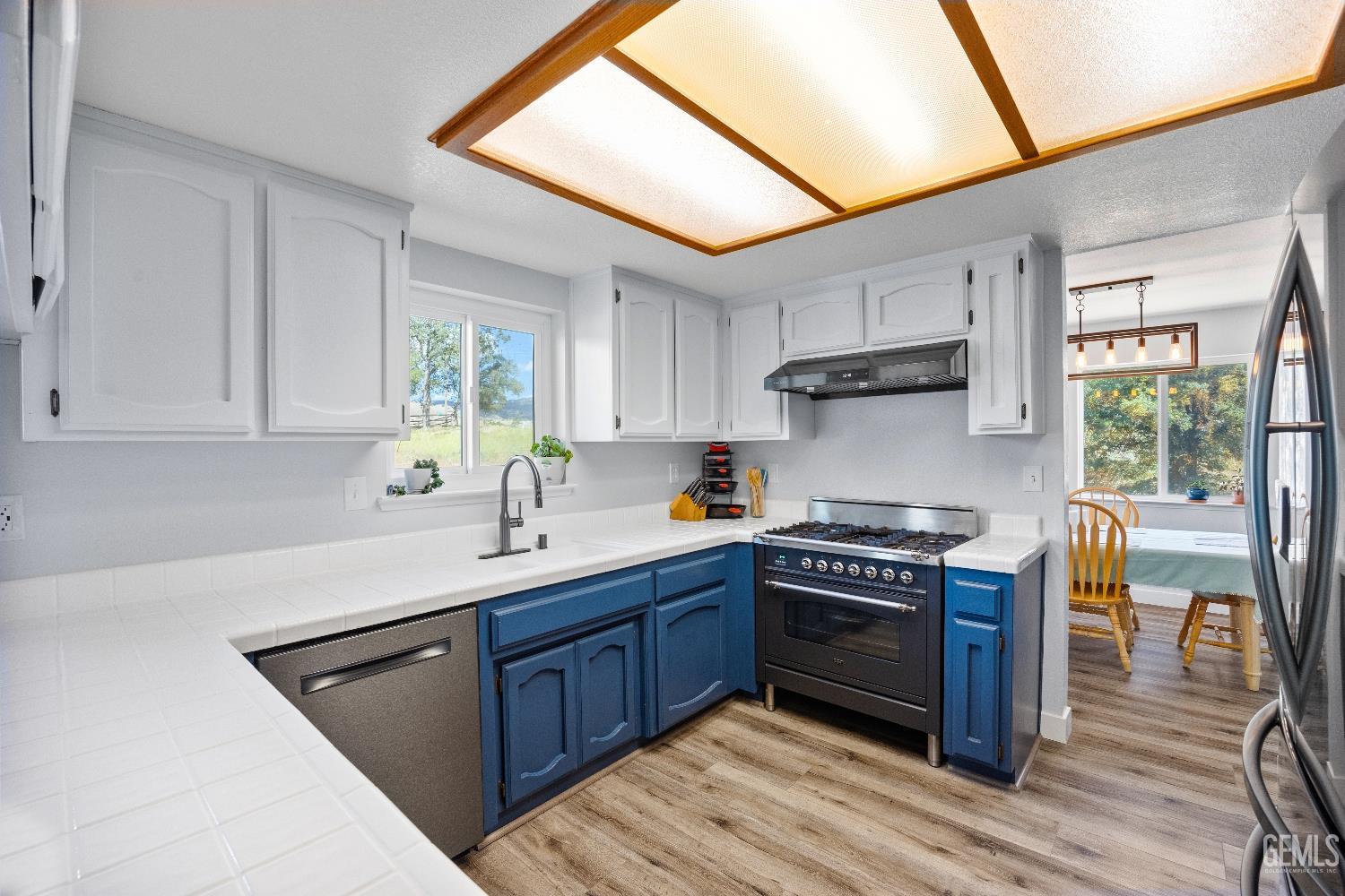 Undisclosed Address Tehachapi, CA 93561 - Photo 15 of 46 a kitchen with stainless steel appliances granite countertop a sink a stove and a wooden floors