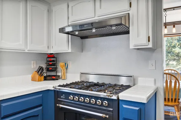 a kitchen with stainless steel appliances granite countertop a sink stove and cabinets