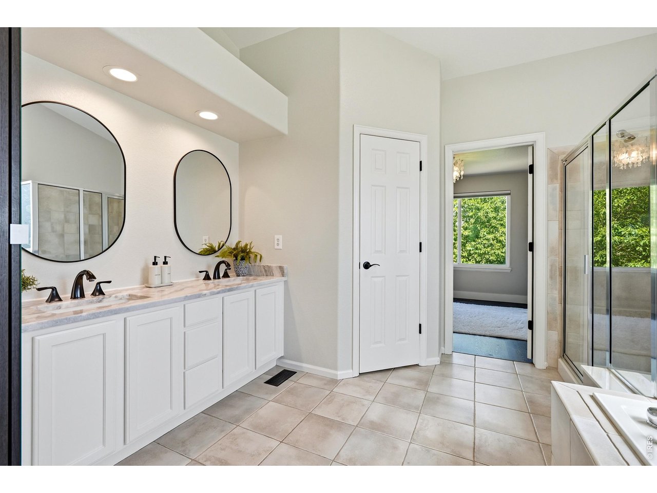 11725 Pleasant Hill Road Longmont, CO 80504 - Photo 28 of 50 Beautifully updated primary bathroom with dual vanity, soaking tub, glass and tile shower, private water closet, and an impressive walk-in closet