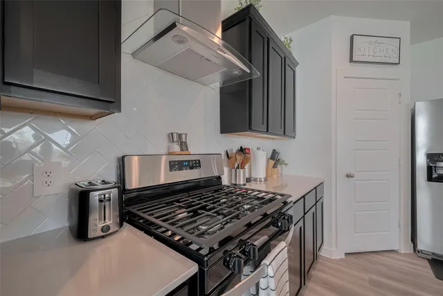 a kitchen with granite countertop a stove and a wooden cabinets