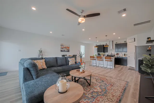 a living room with furniture kitchen and a table