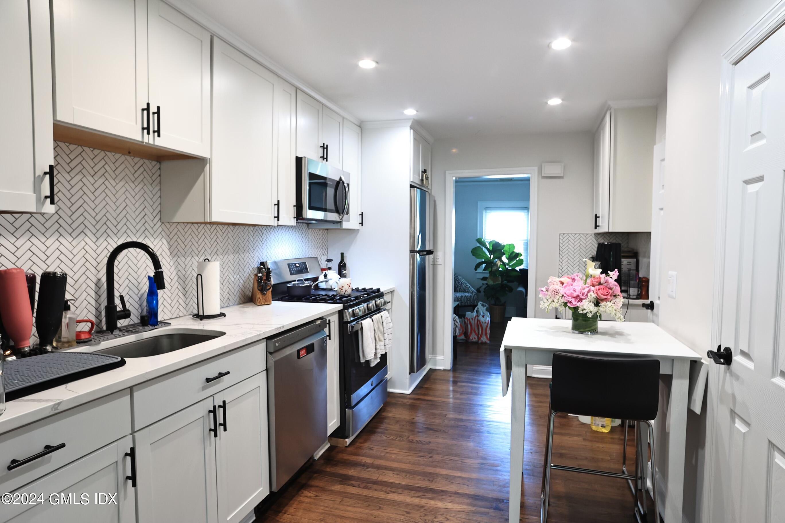 4 Silver Street, Unit B Greenwich, CT 06830 - Photo 9 of 24 a kitchen with a sink stove and cabinets