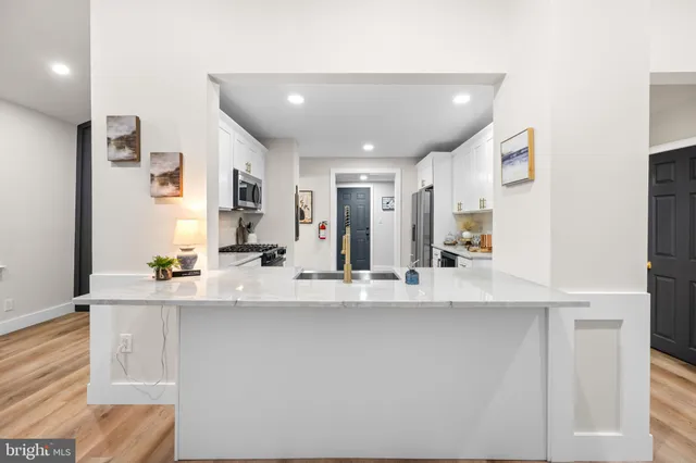 a view of a kitchen with kitchen island a sink and wooden floor