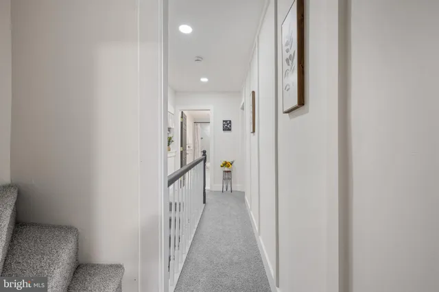 a view of a hallway with wooden floor and entryway