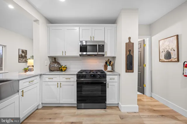 a kitchen with white cabinets and stainless steel appliances