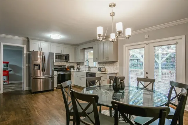 a kitchen with refrigerator cabinets dining table and chairs