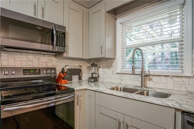 a kitchen with granite countertop a sink and a stove