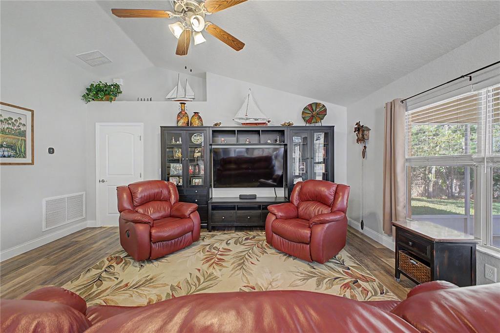 11213 Flock Avenue Weeki Wachee, FL 34613 - Photo 16 of 46 a living room with furniture a fireplace and a window