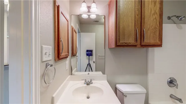 a bathroom with a toilet sink and mirror