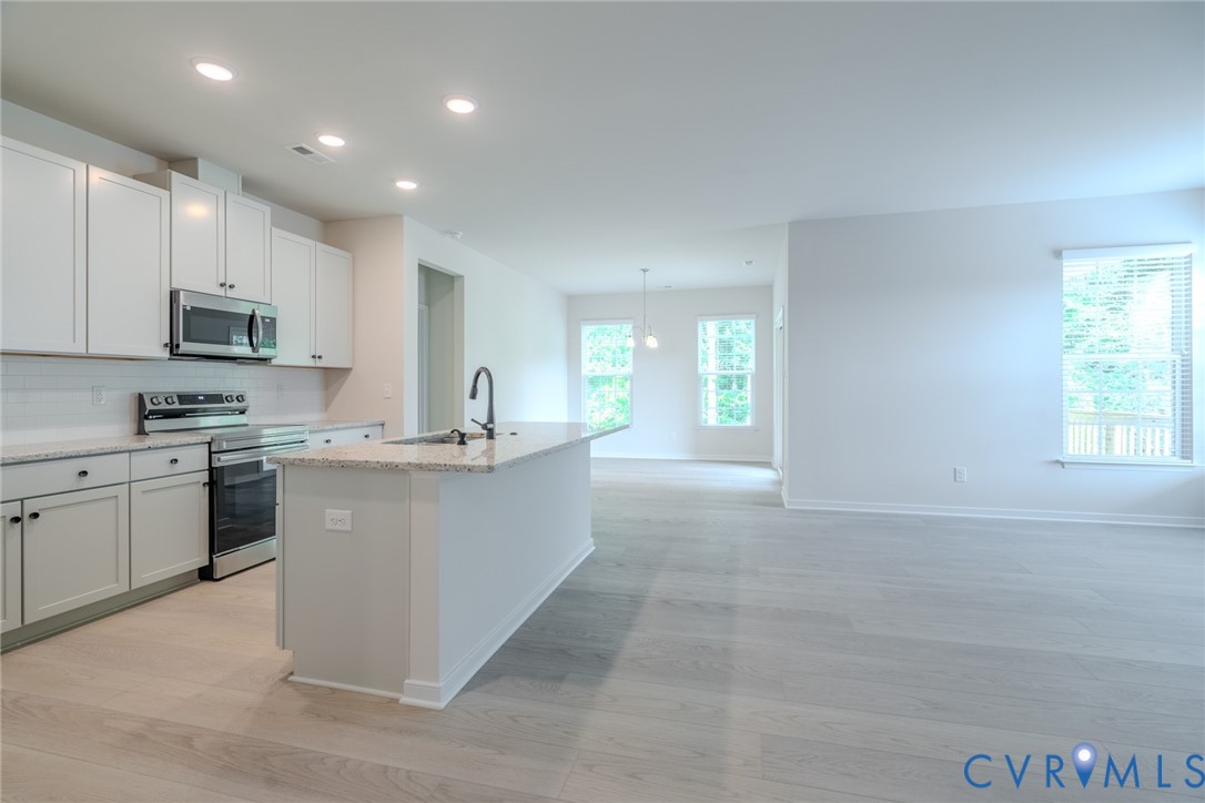 0 Canoe Pointe Loop, Unit 992 Moseley, VA 23120 - Photo 2 of 20 a large kitchen with kitchen island granite countertop a stove a sink a refrigerator and a microwave