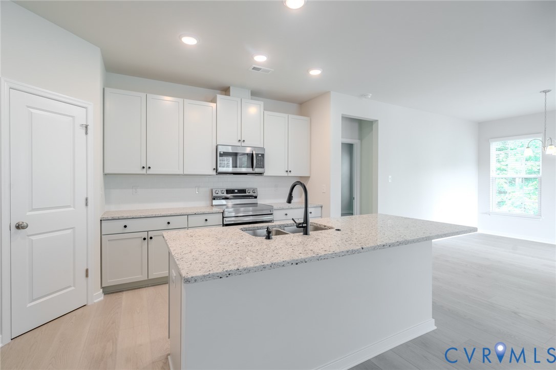 0 Canoe Pointe Loop, Unit 992 Moseley, VA 23120 - Photo 4 of 20 a kitchen with a sink white cabinets and stainless steel appliances