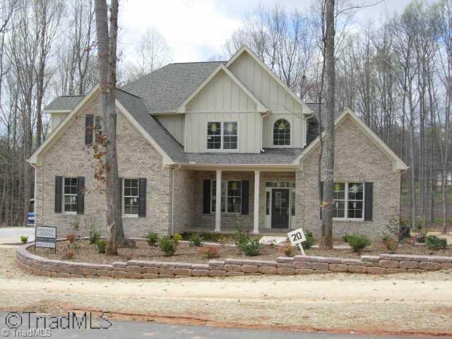 505 Starfire Court Oak Ridge, NC 27310 - Photo 1 of 4 Exterior Front. Exterior of home featuring planting bed with decorative stone wall and accent down lighting