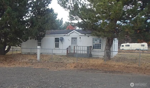 a white house that has a tree in front of it