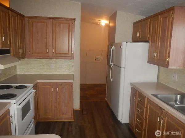 a kitchen with a refrigerator sink and cabinets