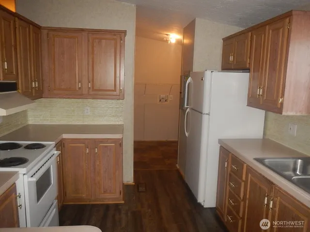 a kitchen with a refrigerator sink and cabinets
