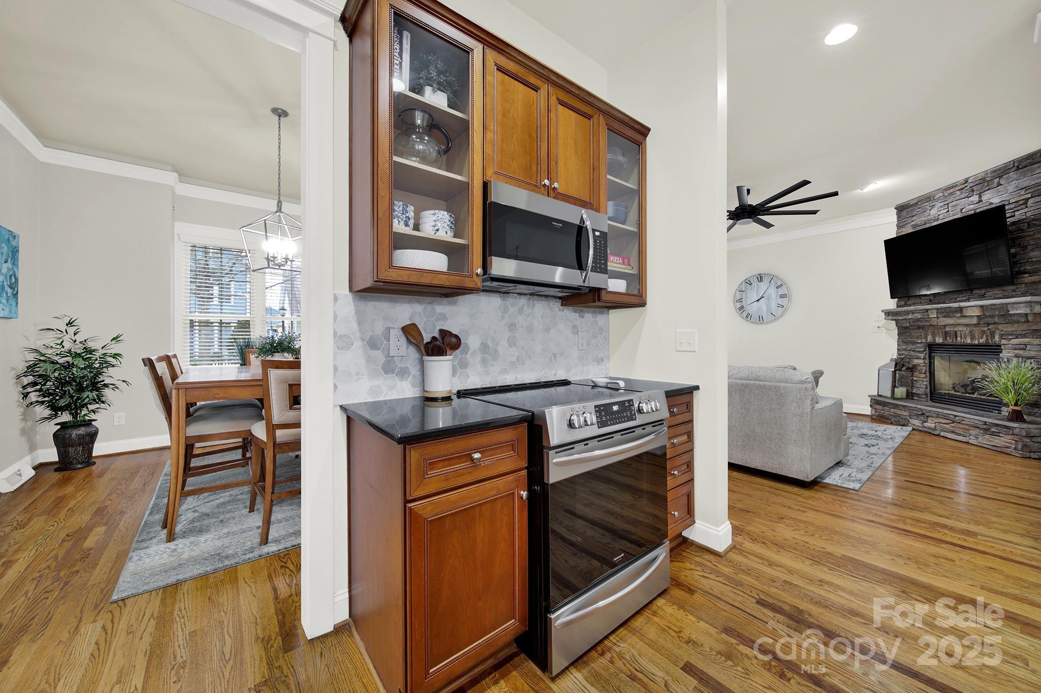 431 Third Baxter Street Fort Mill, SC 29708 - Photo 8 of 39 a kitchen with stainless steel appliances granite countertop a stove top oven a sink dishwasher a dining table and chairs with wooden floor