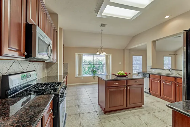 a kitchen with granite countertop cabinets and window