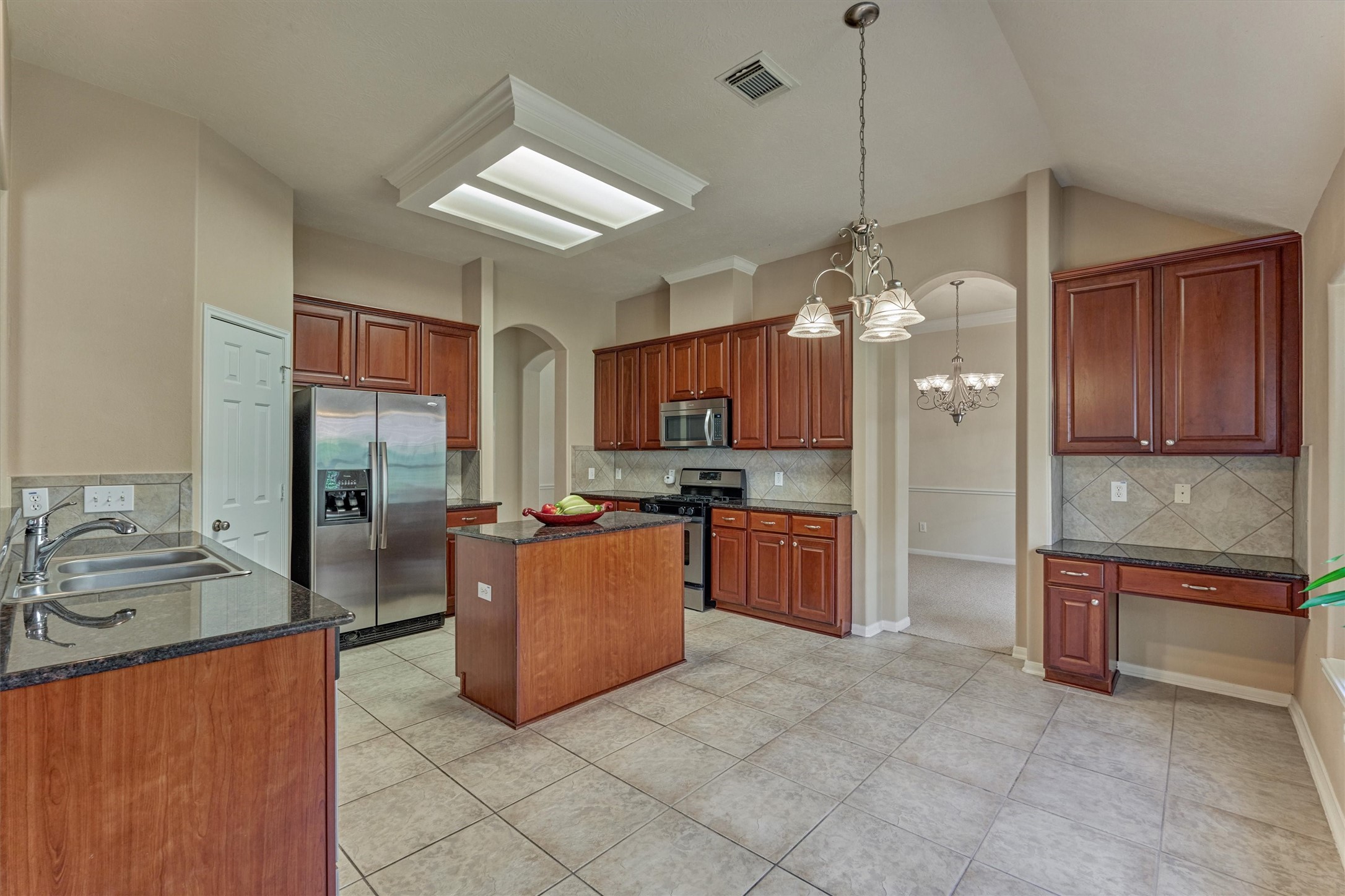 24910 Corbin Gate Drive Spring, TX 77389 - Photo 17 of 49 a kitchen with stainless steel appliances granite countertop a refrigerator a sink dishwasher a oven and a dining table with wooden cabinets