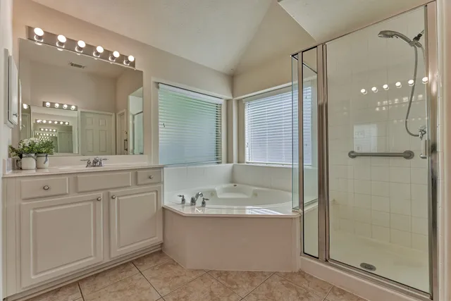 a bathroom with a tub a shower a sink and mirror